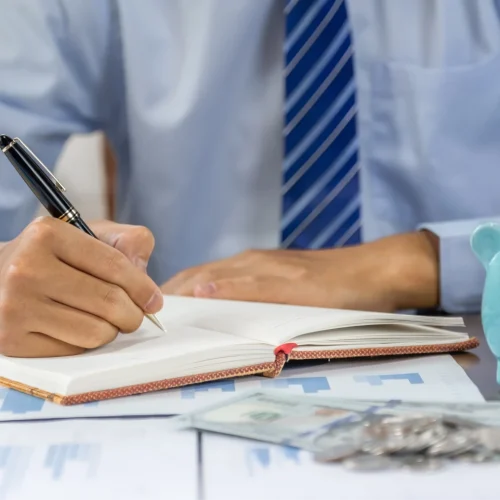 businessman-hand-writing-income-and-expenses-to-ac-2023-11-27-05-22-01-utc